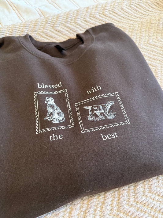 Brown sweatshirt with tan Blessed with the Best text and animal illustrations on a textured surface. Sweatshirt is perfect for cool dog walking days and a chilly Thanksgiving.