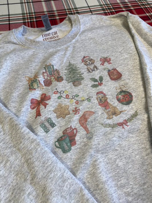 Flat lay of Gildan 18000 ash Christmas dog sweatshirt with watercolor holiday dog collage, cozy winter dog lover clothing, neutral aesthetic Christmas apparel, soft fleece crewneck for holiday gifts, displayed on red and green plaid background.
