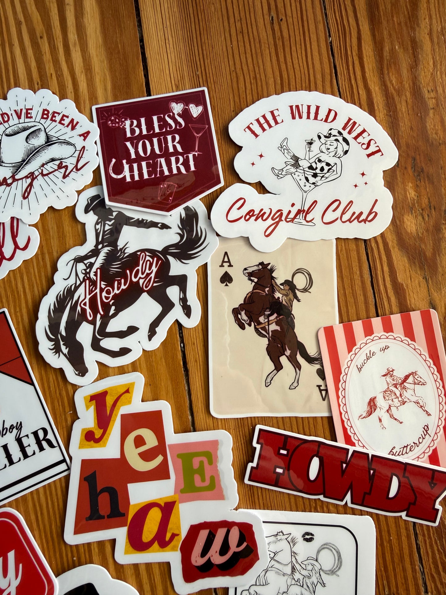 Trendy western stickers including "Wild West Cowgirl Club" and "Buckle Up Buttercup" in retro typography; waterproof desert aesthetic accessories for journals and coolers.