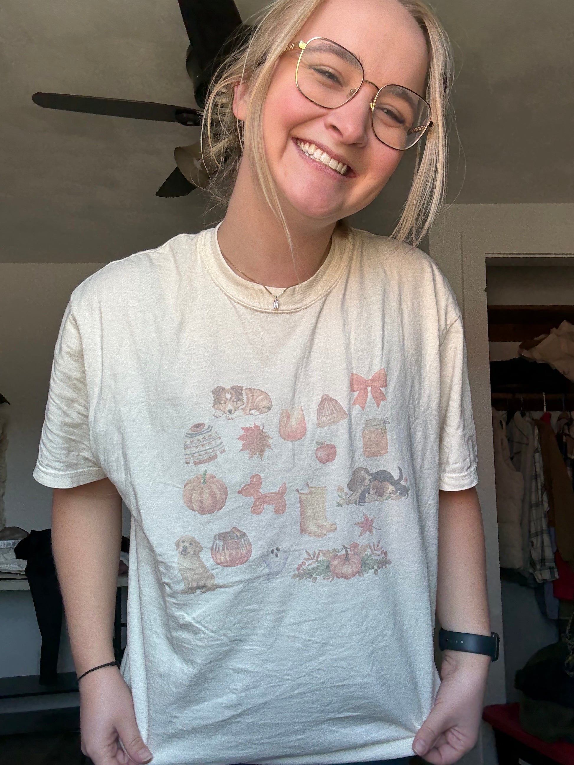Comfort Colors ivory t-shirt with sublimated watercolor fall dog collage worn by a girl with jeans, styled for casual autumn outfits. Dog lover fall graphic tee with rustic watercolor pumpkins, leaves, and pets. Cozy fall outfit idea for women who love dogs. Trendy Comfort Colors fall dog shirt aesthetic for Thanksgiving and pumpkin patch outfits.
