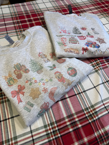 folded christmas cat collage crewneck next to matching dog watercolor christmas sweatshirt, ash gildan 18000 holiday pet themed apparel on red plaid, cute cat and dog matching christmas sweatshirts for pet parents, cozy gift set for animal lovers