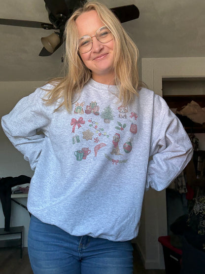 Person wearing watercolor dog Christmas collage sweatshirt in ash gray, Gildan 18000 unisex crewneck for dog parents, cute festive pet-themed holiday top, cozy winter outfit for dog lovers styled with everyday casual clothing.