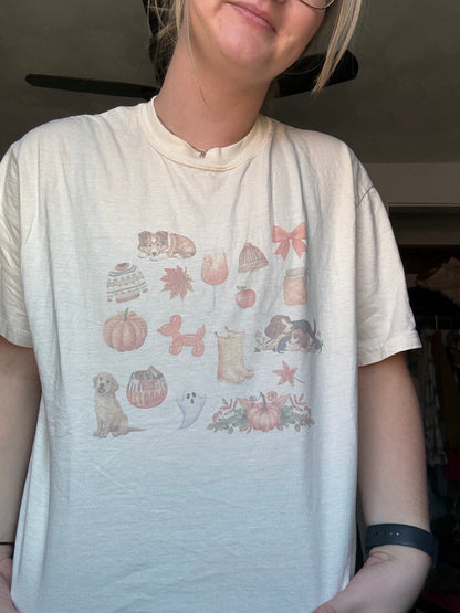 Close-up of Comfort Colors ivory fall dog t-shirt featuring sublimated watercolor collage of autumn leaves, dogs, pumpkins, and cozy fall illustrations. High-quality sublimation graphic tee for dog moms. Neutral fall outfit idea with soft-washed Comfort Colors top. Unique watercolor fall pet lover shirt for seasonal wardrobe.