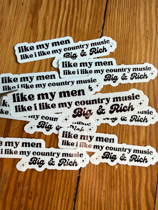 Single vinyl country music sticker featuring the quote “I like my men like I like my country music, Big & Rich,” shown hovering over a background of printed photos. This humorous country lyric inspired sticker is ideal for fans of Big & Rich, southern sayings, cowgirl humor, country concert merch, car decals, planner stickers, and unique country themed gifts for women and men.