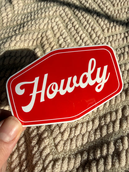 Handheld "Howdy" sticker with bold red background; minimalist western typography decal, waterproof and scratch-resistant for phone cases.