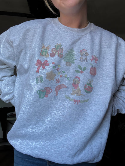 Person wearing Ash Gildan 18000 crewneck featuring watercolor dog and Christmas art, cozy winter dog mom sweatshirt for holiday season, unisex Christmas dog lover gift, festive watercolor dog collage sweater worn for casual holiday fashion.