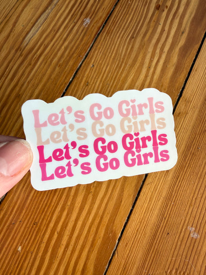 Let’s Go Girls pink typography sticker on wooden background, western cowgirl aesthetic vinyl sticker with four Let’s Go Girls phrases in different shades of pink, country girl sticker for water bottle, laptop, journal, pink cowgirl decor sticker